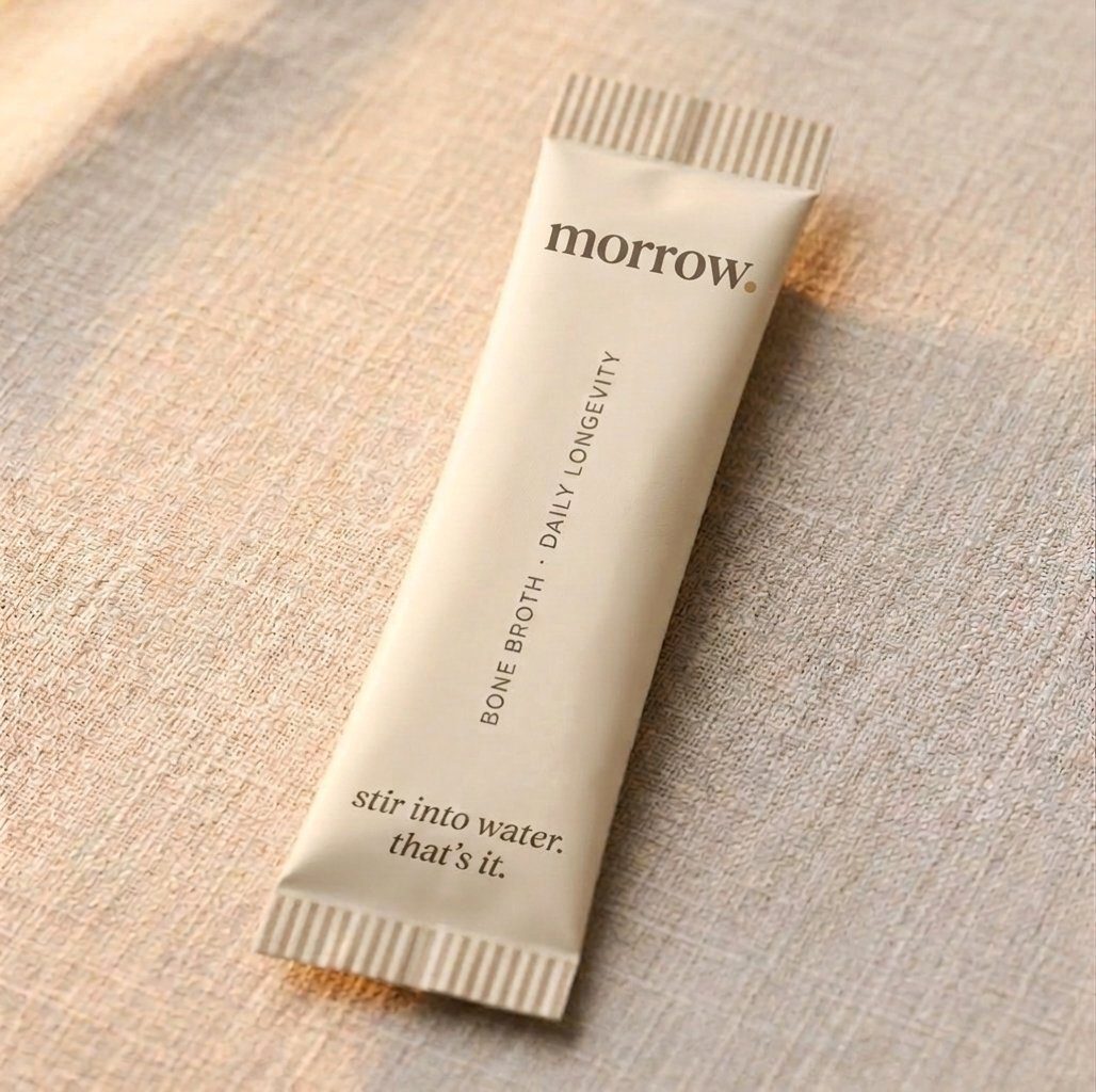 A single morrow bone broth packet on linen: stir into lukewarm water, that's it